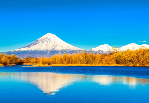 The Koriakski volcano in autumn evening with reflection on the lake. Kamchatka peninsula