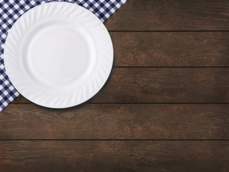 The Blue tablecloth on cage and empy plate on wooden table background
