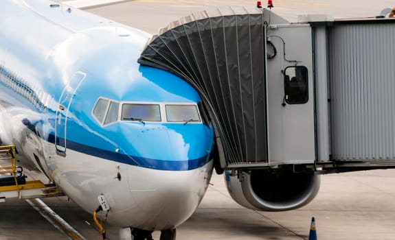 jet bridge attached to the fuselage of a commercial aircraft to allow travelers to board. Passenger boarding operations at an international airport