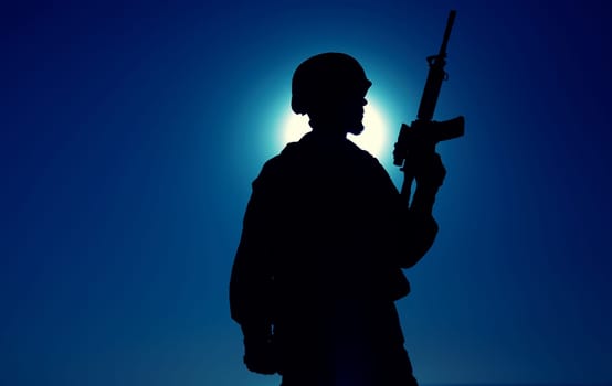 Silhouette of army soldier standing with service rifle in hand on background of night sky with moon. Armed Marines infantry in battle helmet and uniform ready for action, patrolling area in darkness