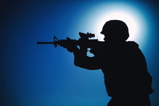 Modern army infantry soldier, coast guard rifleman aiming assault rifle with collimator sight at night. Special operations forces fighter engaging enemy in darkness, observing territory during mission