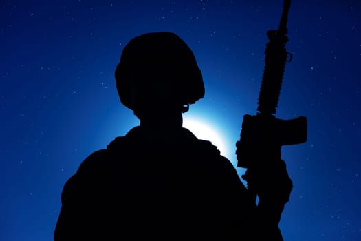 Night silhouette of army special operations forces soldier standing with service rifle on background of night sky with moon and stars. Modern warfare combatant in helmet, Marines raider in darkness