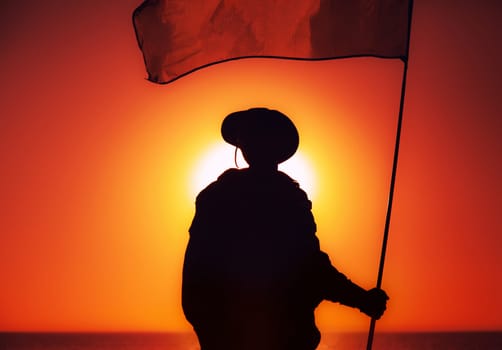 Silhouette of army soldier, commando fighter special forces infantryman standing on background of sunset sky waving on flagpole flag. Military victory, remembrance of fallen soldiers, veterans concept