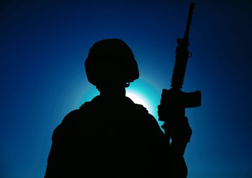 Night silhouette of army special operations forces soldier standing with service rifle on background of night sky with moon and stars. Modern warfare combatant in helmet, Marines raider in darkness