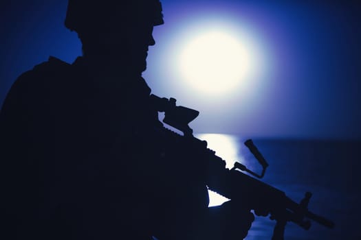 Silhouette of army infantryman standing with light machine gun on background of night sky with moon. Commando soldier in ammunition patrolling coastline, sneaking in darkness during night mission