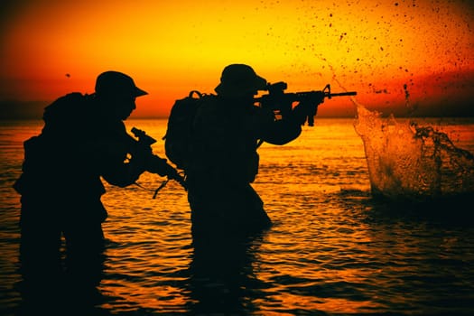Army soldiers team, special operation forces infantrymen landing on seacoast, aiming and shooting with service rifle during firefight on shore at evening or morning time. Military amphibious operation
