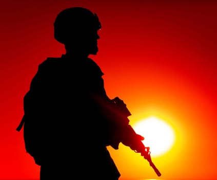 Silhouette of army special forces rifleman, Marines, coast guard or anti-terrorist squad soldier in ammunition and helmet, armed service rifle, standing on ocean shore, patrolling seacoast at sunset