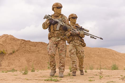 Equipped and armed special forces soldiers in the desert. Concept of military operations.