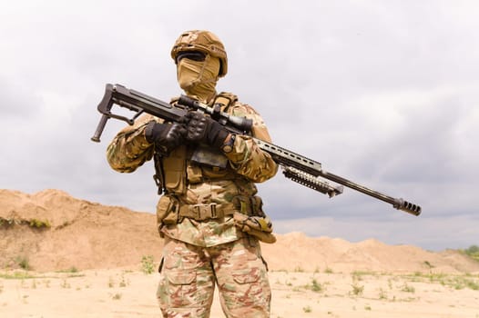 Soldier in camouflage holding sniper rifle close-up