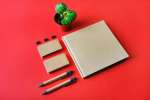 Photo of blank kraft stationery set on red paper background. Template for branding identity. Identity set mock-up.