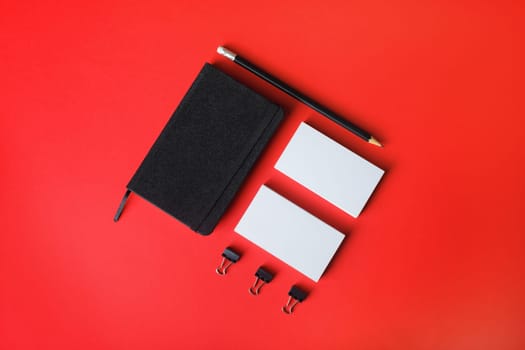 Blank corporate stationery set on red paper background. Template for branding design. Branding mock up. Flat lay.