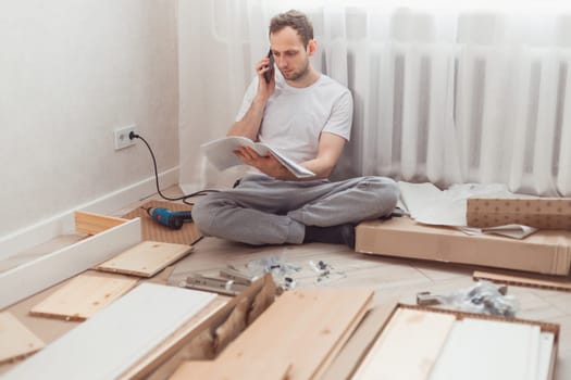 Man customer calls to help center at home during assembling new furniture, calling for a master