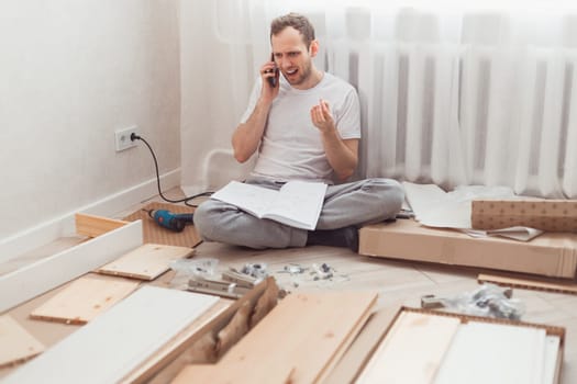 Anger man, dissatisfied with quality of delivered furniture, complaints by phone about poor quality service. Assembling furniture at home after moving
