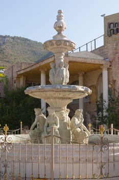 Antique fountain at garden. Blue water flowing from stone fountain. Design of antique fountain