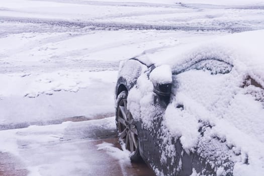 The car in the snow, covered with a white drift of snow.