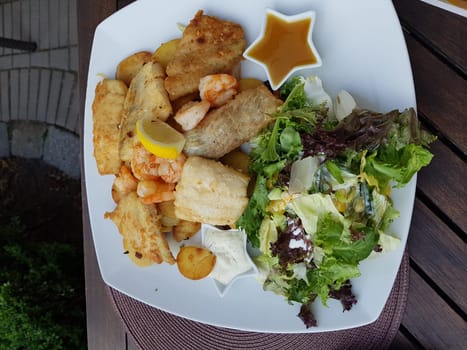 Plate of different fish served on a white plate