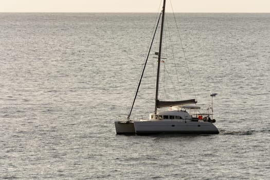 Yacht - catamaran in the tropical sea at sunset. Yachting / luxury sailing theme