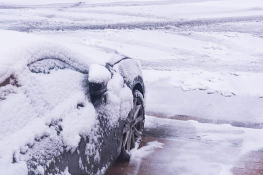 The car in the snow, covered with a white drift of snow.