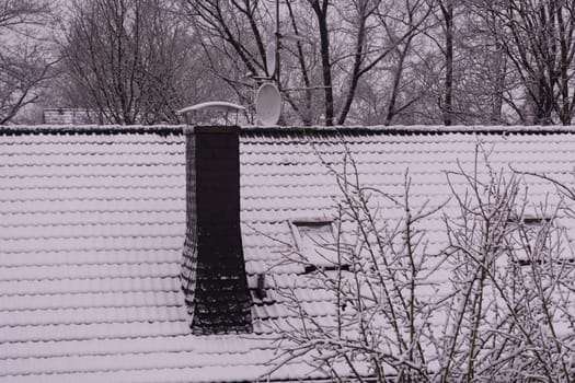 Snow covered roof and cloudy sky.