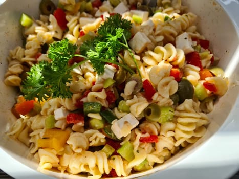 Bowl of fusili pasta salad with fresh vegetables