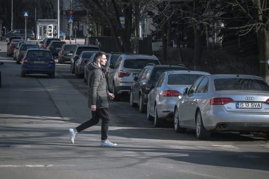 Iasi - Romania - 13th March 2021: Guy crossing the street