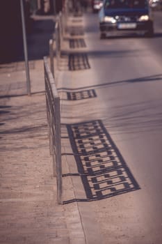 Shadow of fence pattern on the street