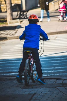 Young boy riding his bike on the sidewalk