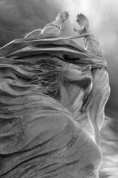 Statue of a woman with arms outstretched upwards. Peace, freedom, Easter concept and more.