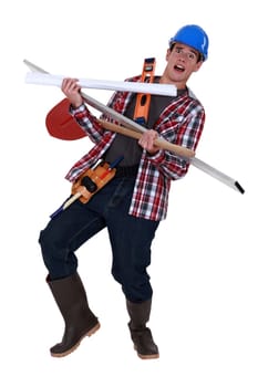 Overwhelmed tradesman carrying building supplies