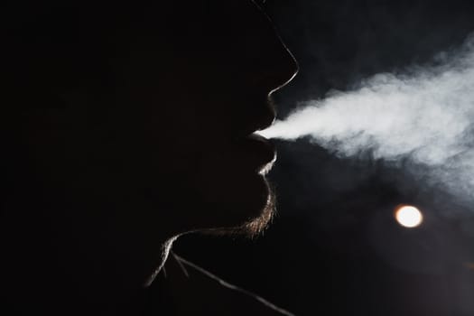 Close up portrait of young man smoking cigarette