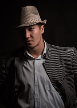 a man in a grey hat on black background