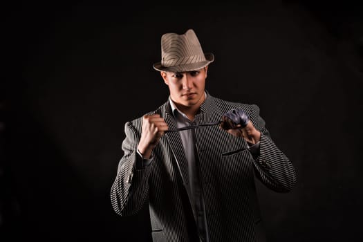 a man in a grey hat on black background
