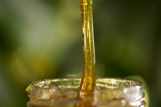 Close-up shot of flowing honey over yellow background