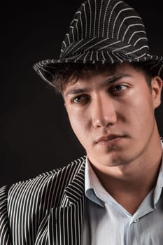 a man in a grey hat on black background