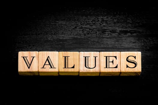 Word Values. Wooden small cubes with letters isolated on black background.Concept image.