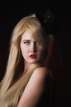 Blond Hair. Beautiful Blond Woman with Holiday Makeup over Black Background. Red Lipstick