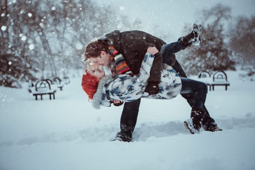 Happy Young Couple in Winter Park having fun.Family Outdoors. love kiss