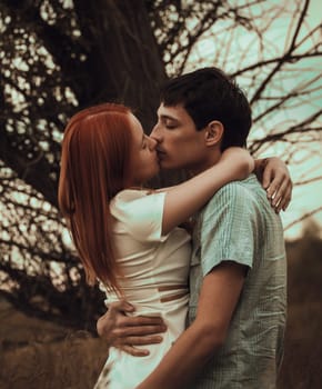 Young couple kissing on autumn field