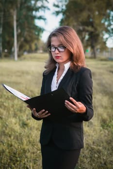 beautiful young girl reading a book on the nature