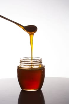 glass of fresh honey on white background
