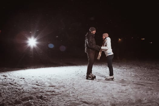 young couple in winter skate rink
