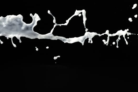milk or white liquid splash on black background