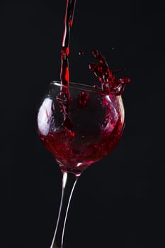 Red Wine Pouring into glass black isolated