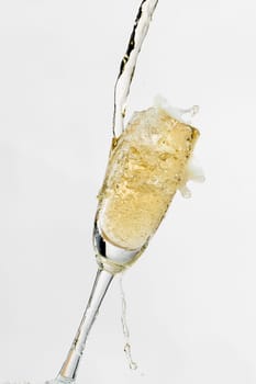 White wine splashing out of glass, isolated on white background