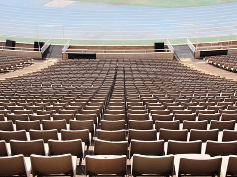 Perspective of Spectator Seats at Sports Arena with Blue Running Lanes  at the distance