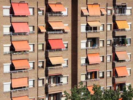 Apartment Building Facade with Red Yellow Awning in the afternoon in Barcelona Spain