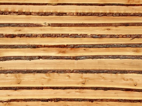 Rough wooden pine planks with bark on the side. It resembles a set of stairs.