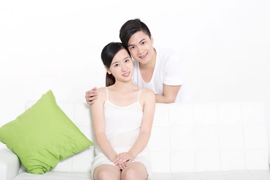 Young Chinese couple showing love in couch