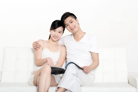Young Chinese couple showing love in couch