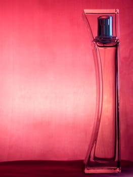 Bottle og perfume over pink background